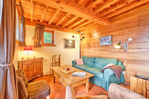 a living room with a blue couch and a table at Chalet il fera beau demain in Villard-Reculas