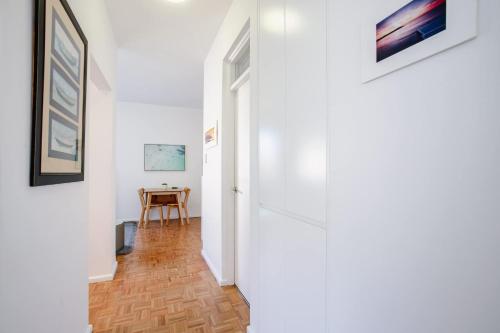 a hallway with a white door and a table at Bondi Getaway - Parking and Walk to the Beach in Sydney