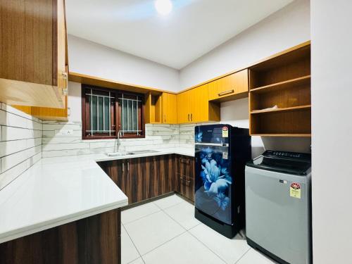 a kitchen with a black and white refrigerator in it at AL-Kabeer City Link suites in Trivandrum