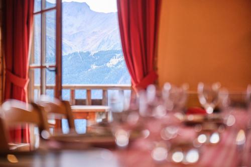 a table with wine glasses in front of a window at Chalet il fera beau demain in Villard-Reculas