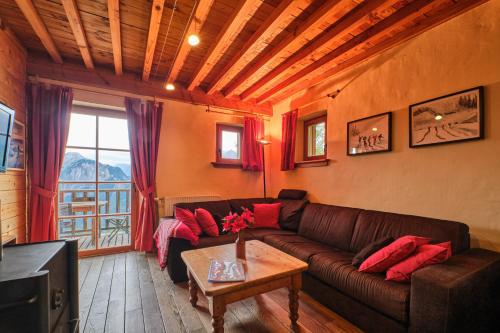 a living room with a couch and a table at Chalet il fera beau demain in Villard-Reculas