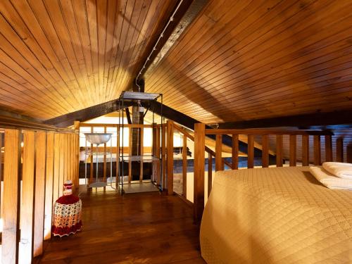 um quarto com uma cama e um teto de madeira em Quintinha do Varoso - Little Red Cottage House em São Pedro do Sul