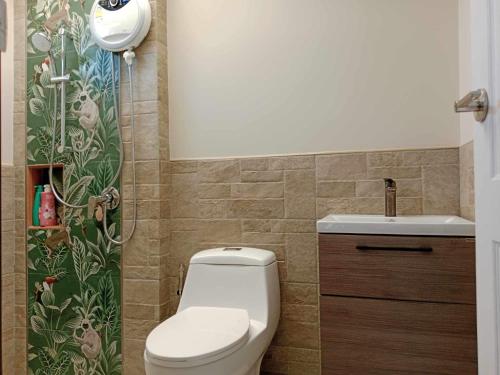 a bathroom with a toilet and a sink at Lan Nam Ob Duen ลานน้ำโอบเดือน in Si Khio