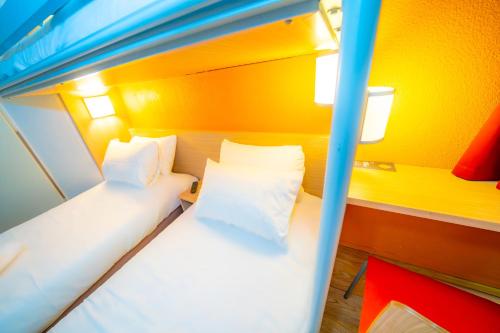 a bunk bed in a room with yellow walls at Premiere Classe Auxerre in Monéteau