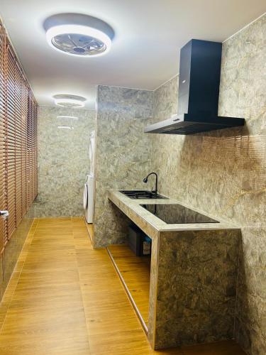 a kitchen with a sink and a stove at Emiri Hotel - Nana Bangkok in Bangkok