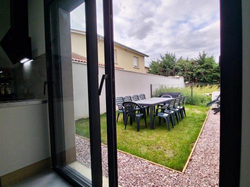 - une vue sur une table et des chaises depuis la fenêtre dans l'établissement Stop Chez M Vibe #Climatisation #Parking #Cozy, à Vénissieux