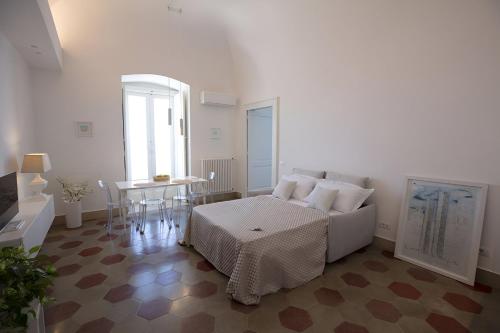 a white living room with a couch and a table at Antica Dimora sul Mare - Luxury Central Apartments - Molfetta in Molfetta