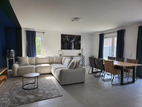 a living room with a couch and a table at Deluxe Ferienwohnung am Rande des Pfälzer Waldes in Schwedelbach