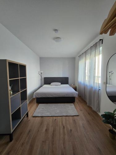 a bedroom with a bed and a wooden floor at Deluxe Ferienwohnung am Rande des Pfälzer Waldes in Schwedelbach