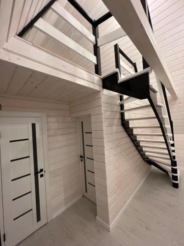 a spiral staircase in a house with a door at Шале WeLKoMe in Verkhovyna
