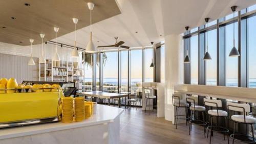 a restaurant with tables and chairs and windows at Beach Front Oasis with Private Courtyard in Gold Coast