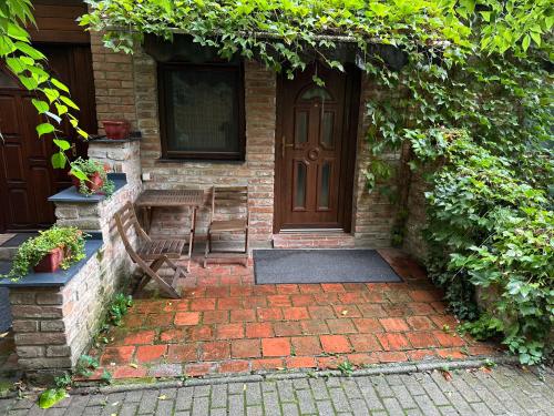 a brick house with a wooden door and a bench at Partapartman in Gyula