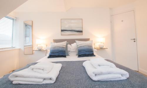 a bedroom with a bed with towels on it at Melfort Pier & Harbour Resort in Kilmelfort
