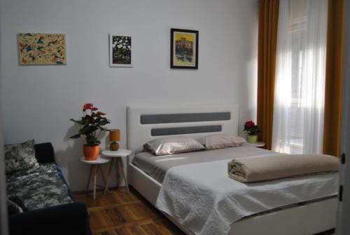 a bedroom with two beds and a couch at Apartment Centar in Podgorica