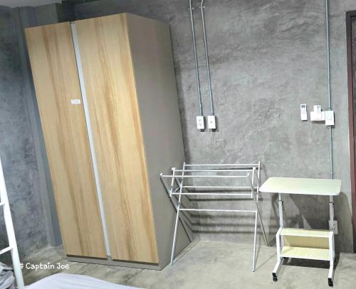 a room with a shower with a desk and a chair at Captain Joe Cafe & Hostel in Hua Hin