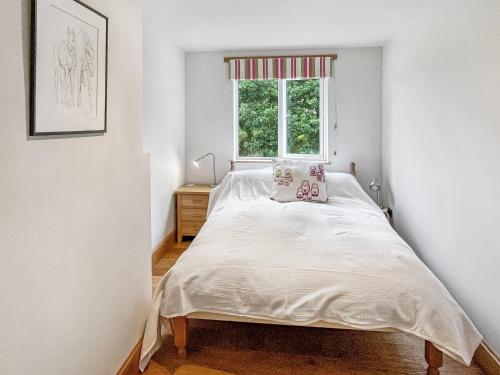 a small bedroom with a bed and a window at Ormrods in Withypool