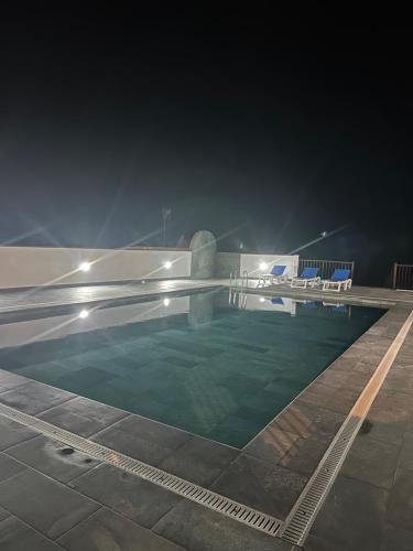an empty swimming pool at night with lights at DORADO ATARDECER Beach Sand in Puerto de Santiago