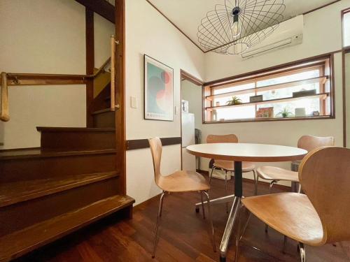 a room with a table and chairs and a piano at ハルノヒハウス-春日部の民泊- Spring Day House in Kasukabe in Kasukabe