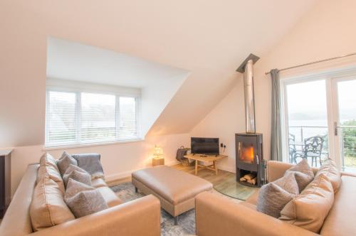 a living room with a couch and a fireplace at Melfort Pier & Harbour Resort in Kilmelfort