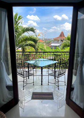a patio with a table and chairs on a balcony at Canggu Surf Villa in Canggu