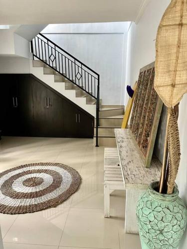a living room with a staircase and a vase at Canggu Surf Villa in Canggu