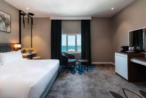a hotel room with a bed and a view of the ocean at Warwick Al Jubail Hotel in Al Jubail