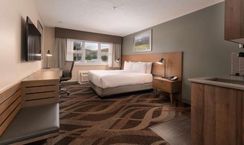 a hotel room with a bed and a sink at Prestige Hudson Bay Lodge & Conference Centre, WorldHotels Crafted Collection in Smithers
