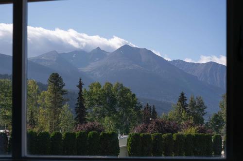 a view of a mountain range from a window at Prestige Hudson Bay Lodge & Conference Centre, WorldHotels Crafted Collection in Smithers
