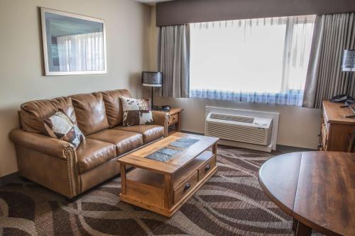 a living room with a couch and a table at Prestige Hudson Bay Lodge & Conference Centre, WorldHotels Crafted Collection in Smithers