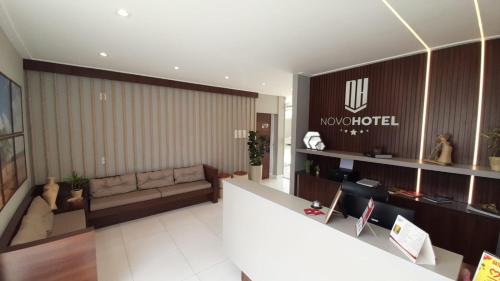 a living room with a couch and a sign on a wall at NOVO HOTEL in Conceição do Coité