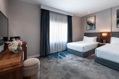 a hotel room with two beds and a television at Warwick Al Jubail Hotel in Al Jubail