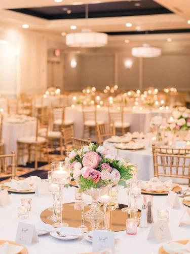 a room filled with tables with white tablecloths at Graduate by Hilton Iowa City in Iowa City