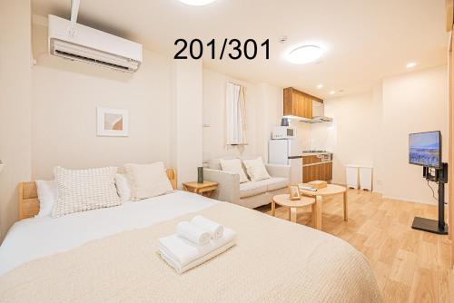 a white bedroom with a bed and a living room at Newly build Family-APT , Shinjuku Shibuya Ueno in 15 minutes by train in Tokyo