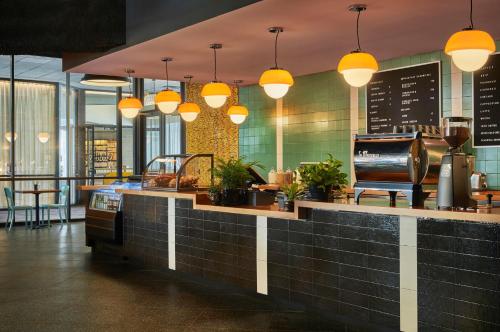 a restaurant with a counter with lights on it at Graduate by Hilton Iowa City in Iowa City