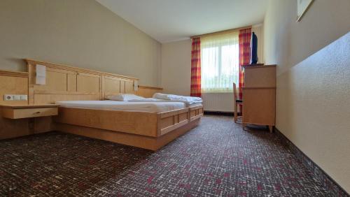 a bedroom with a large bed and a window at Pension Familie Dunkl in Dietmannsdorf