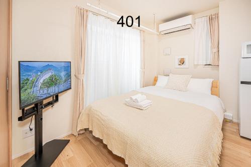 a bedroom with a bed and a flat screen tv at Newly build Family-APT , Shinjuku Shibuya Ueno in 15 minutes by train in Tokyo