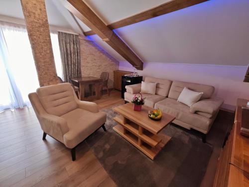 a living room with a couch and a table at Green Land Club in Novi Banovci