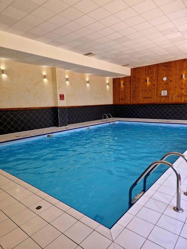 une grande piscine avec de l'eau bleue dans un immeuble dans l'établissement Duplex 7 personnes au pied des pistes LES HAUTS DE VALMEINIER B 506, à Valmeinier