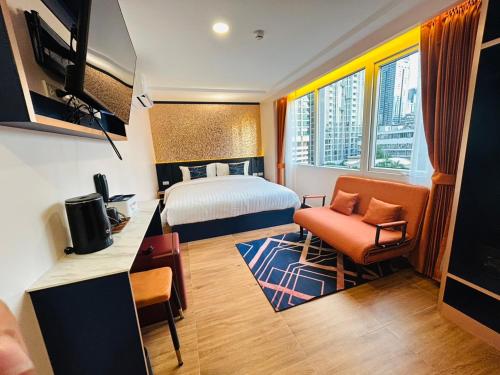 a hotel room with a bed and a desk and chair at Emiri Hotel - Nana Bangkok in Bangkok