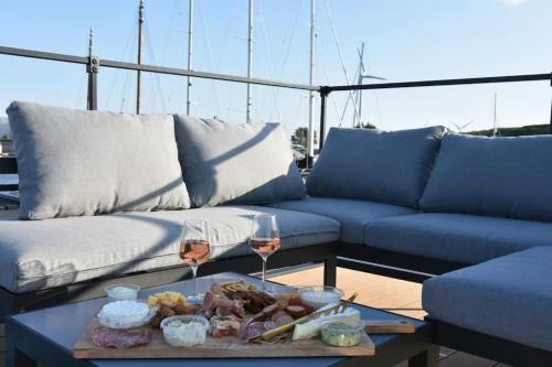 a couch and a table with wine glasses on a boat at Moderne houseboat op het water! in Assendelft
