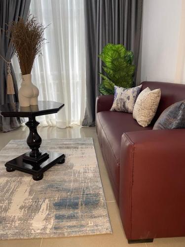 a living room with a couch and a table at Wine House, Maitama, Abuja in Abuja