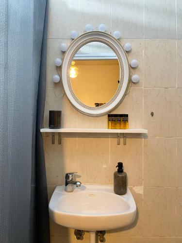 a bathroom with a sink and a mirror on the wall at Dotan's Boutique Apartments - By The Beach! in Tel Aviv