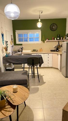 a kitchen and living room with green walls at Dotan's Boutique Apartments - By The Beach! in Tel Aviv