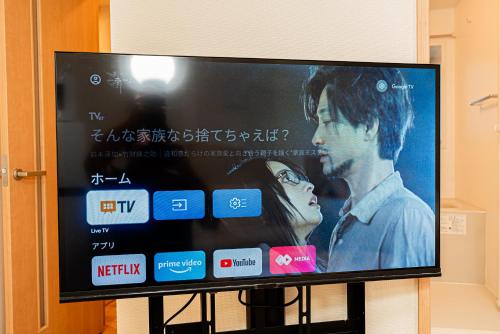 a flat screen tv with a movie on it at Newly build Family-APT , Shinjuku Shibuya Ueno in 15 minutes by train in Tokyo