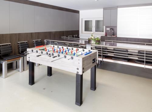 a foosball table in the middle of a room at Villa Schmidt - Strandhaus direkt am Meer mit Sauna, Sport und Dünengarten I in Warnemünde