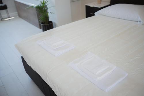 a white bed with two white towels on it at Suite La PerlaNera- TorreCanne in Torre Canne