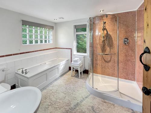 a white bathroom with a tub and a shower at Gardener’s Cottage Martinhoe in Martinhoe