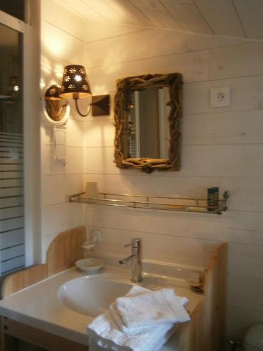 une salle de bain avec un lavabo et un miroir dans l'établissement Le Relais du Haras A la campagne, à Champagné-Saint-Hilaire