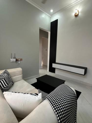 a living room with a white couch and a table at Amazing home stays 9 in Dar es Salaam