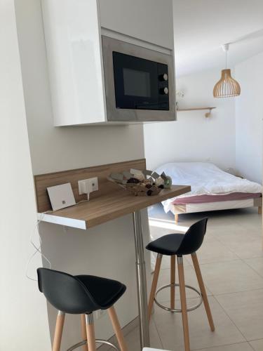 une pièce avec une table et deux chaises et un lit dans l'établissement Studio style loft, à Mantes-la-Jolie